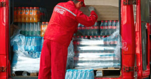 A Coca-Cola employee inspects a van of Coca-Cola soda.